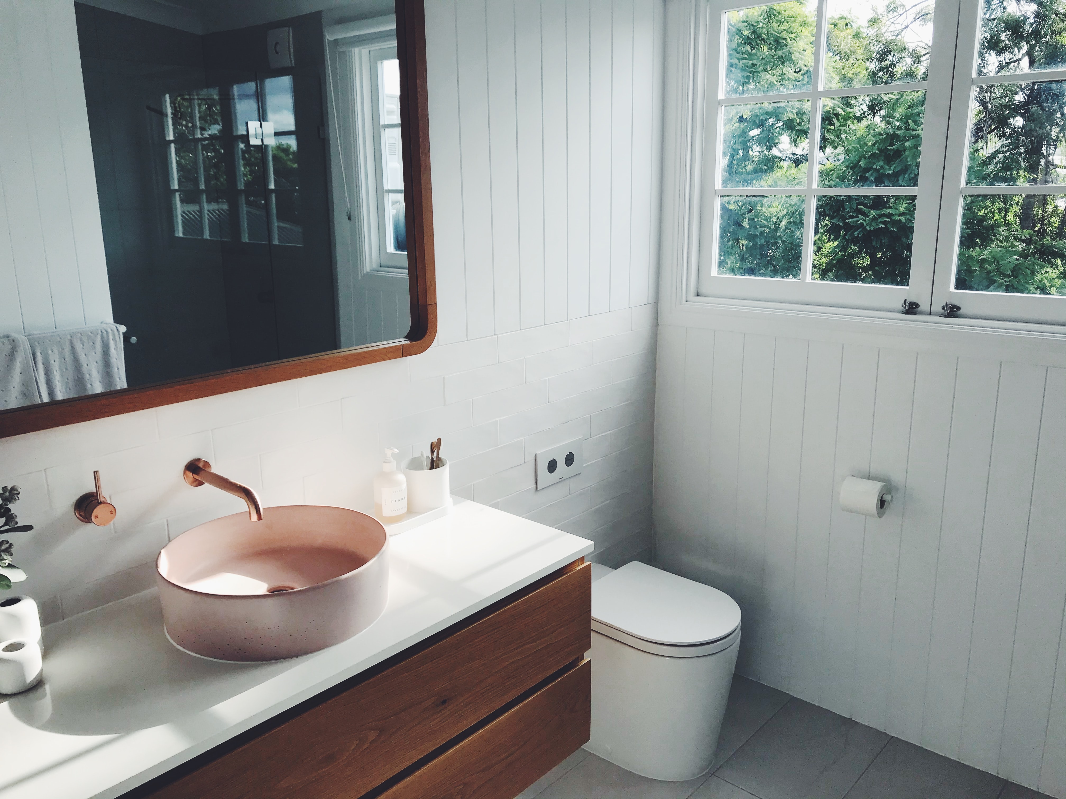 Renovated bathroom blush pink stone basin and oak finishes